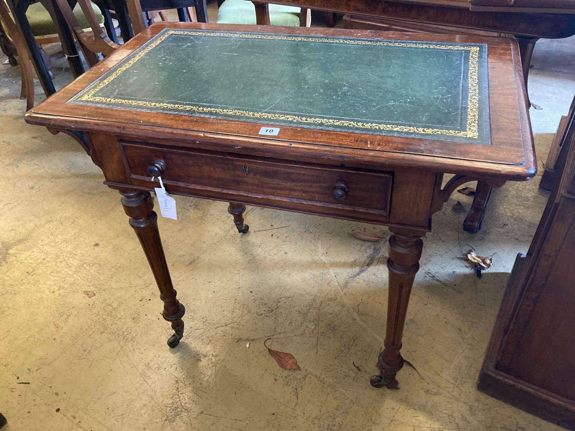 A late Victorian mahogany writing table, with leather lined top and ceramic castors, width 88cm